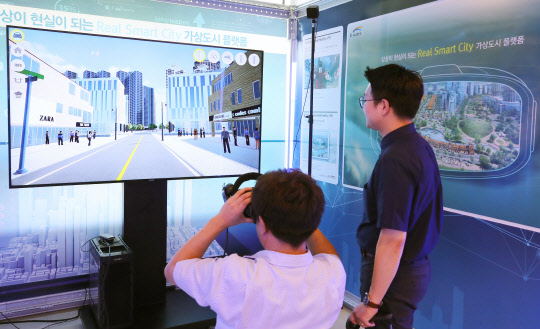 대통령 직속 4차산업혁명위원회와 국토교통부는 16일 오후 상암 DMC 첨단산업센터에서 정부가 세종시와 부산에서 추진하는 스마트시티 국가 시범도시 기본구상을 공개했다.      한 관계자가 행사장에 마련된 부산 스마트 에코델타시티 부스에서 가상공간 체험을 하고 있다.